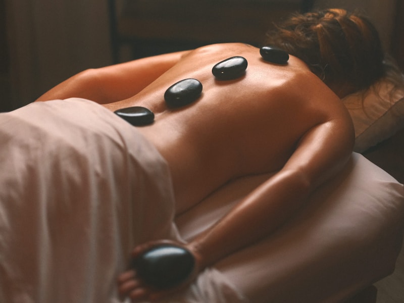 Heated stones positioned along a client's back during a modality-led treatment